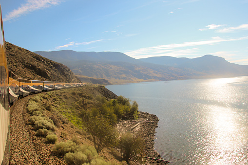 Rocky Mountaineer travelling around a bend alongside Mckenzie River