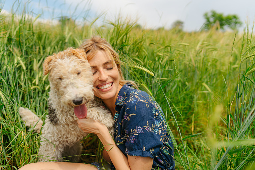 Photo of a woman and her puppy savouring nature side by side