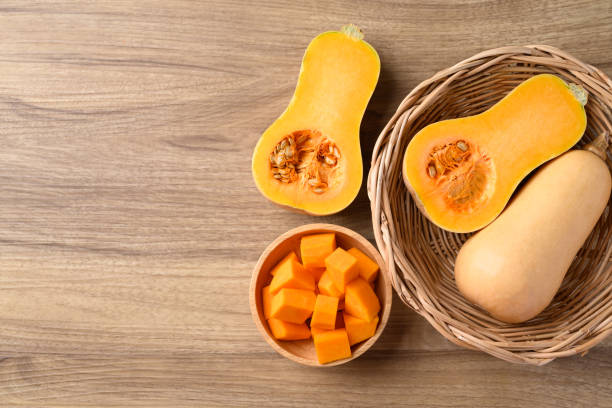 istock Half and sliced butternut squash pumpkin on wooden background 1899368095
