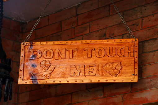 Do not touch me signboard in front of a museum. Don't touch me sign.