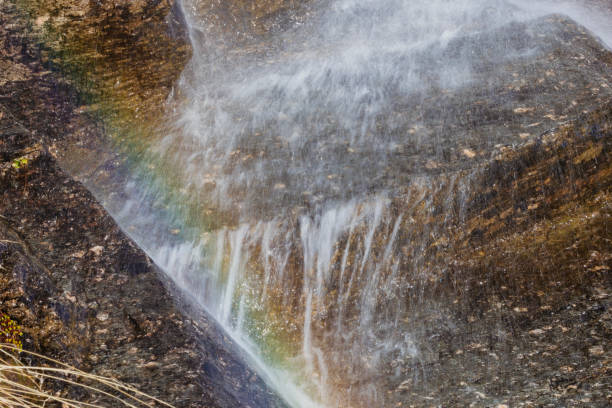Waterfall with rainbow among the rocks.