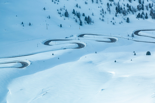 Curvy road in high snow at Pordoi pass.