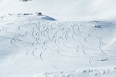 Trails in powder snow at winter ski resort