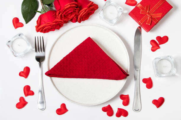 istock Table setting for valentine's day. Red roses and cutlery on a white background. 1899444228