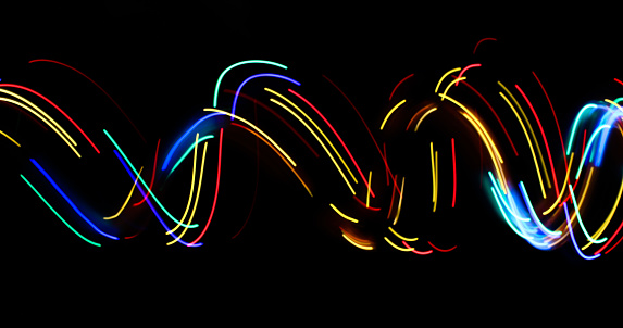 A long exposure photo, light painting photograhy, using fairy lights in a dark room to create neon symbols and patterns