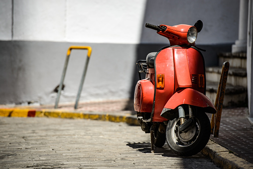 Red old fashioned moped on a cozy street