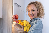 A girl at home with a shopping bag full of fruit