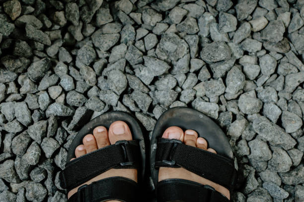 istock feet, sandals and pebbles 1899504862