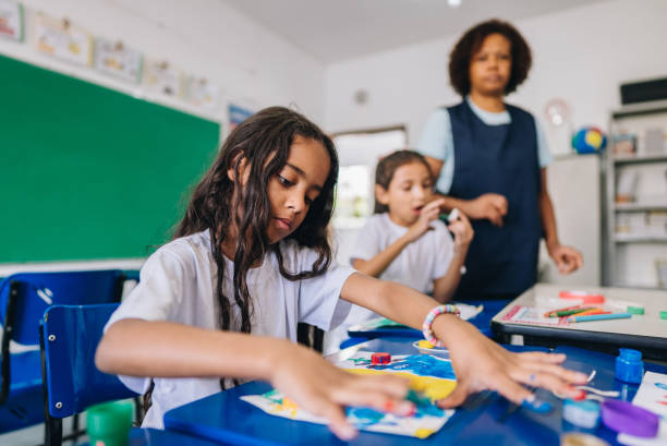 istock Girl student painting on art class at school 1899574280