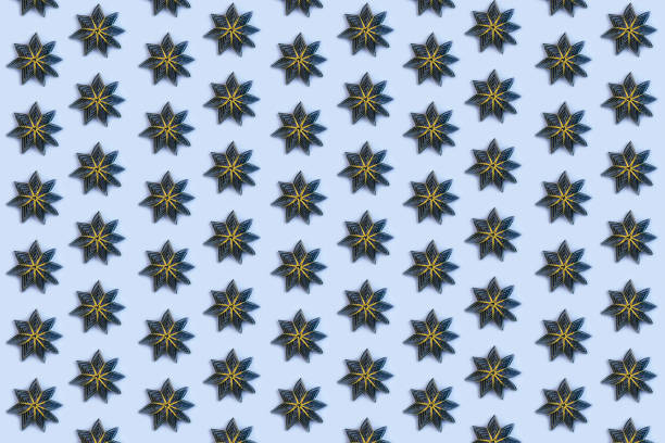 Christmas bauble abstract pattern on blue background. Black paper snowflake shape toy, New Year decorations. Top view, flat lay, wallpaper.