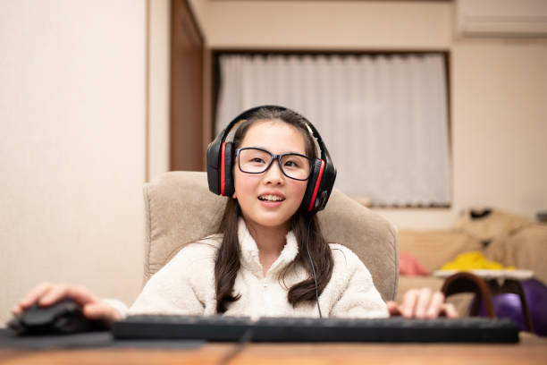 istock A girl wearing headphones and operating a computer 1899605413