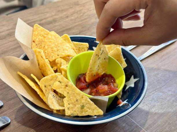 a hand is taking a corn snack stock photo