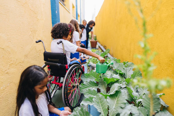 Girl student using wheelchair its doing gardening at school