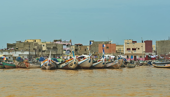 Saint Louis. Senegal. October 10, 2021. Traditional fishing boats at the berths of the city harbor at the mouth of the Senegal River.