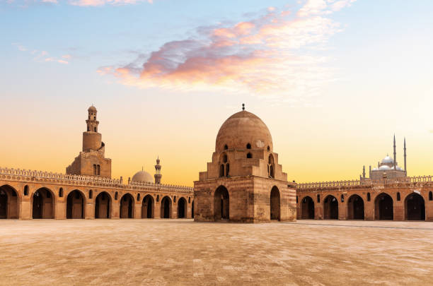 minarete e fonte de ablução da mesquita ibn tulun, vista do pôr do sol de um lugar famoso do cairo, egito - courtyard arch arabic style cairo - fotografias e filmes do acervo