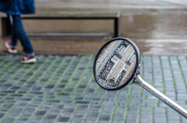 Detail of the reflections in a rearview mirror of a motorcycle parked on the street