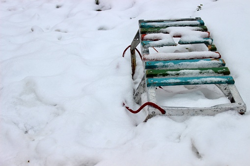 Children's wooden sled in the yard in winter on snow