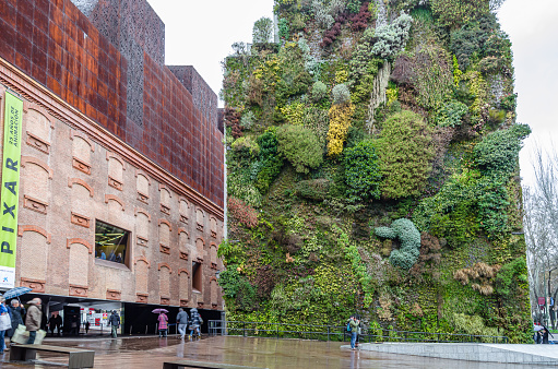 Madrid, Spain - March 1, 2014: The CaixaForum cultural center in Madrid, Spain, accompanied by a vertical garden, the work of French landscape designer Patrick Blanc
