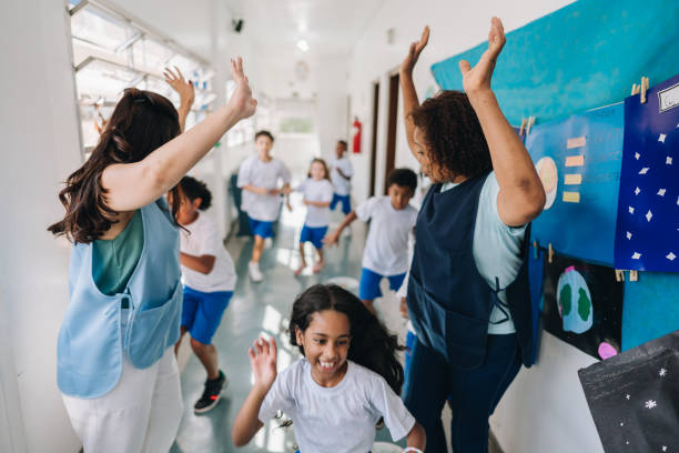 istock Students running between the teachers on corridor at school 1899706690
