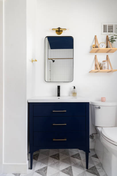istock A bathroom detail with a pattern tile floor and dark blue cabinet. 1899715946