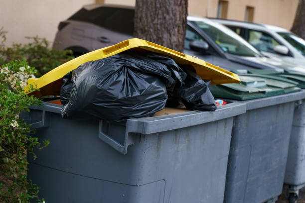 istock A gray trash can filled with trash, topped with a yellow lid 1899718542