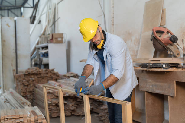 istock Male carpenter checking piece of wood. Builder worker working with wood. Male construct making furniture in factory woodwork. Concept of wood industrial factory 1899735001