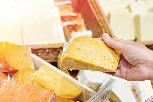 Cheeses in hand on shop