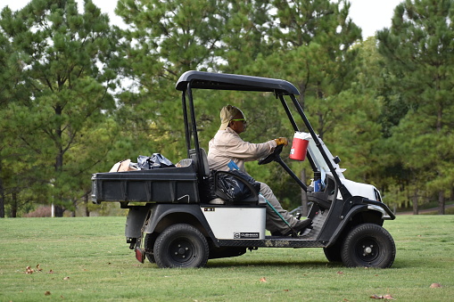 Houston, TX USA 7-26-2023 Portrait of a gardener driving a Golf Cart in Allen Parkway