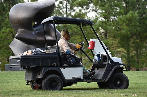 Houston, TX USA 7-26-2023 Portrait of a gardener driving a Golf Cart in Allen Parkway