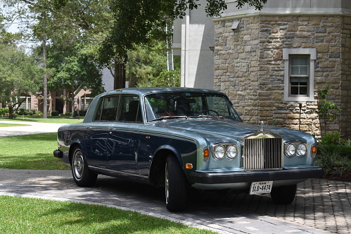 Paris, France - September 12, 2016: Headlight and logotype of a exclusive Luxury Rolls-Royce car limousine parked in city during fashion wedding vip event waiting for passenger. Rolls-Royce Limited is a British car-manufacturing and, later, aero-engine manufacturing company founded by Charles Stewart Rolls and Sir Frederick Henry Royce on 15 March 1906 as the result of a partnership formed in 1904.