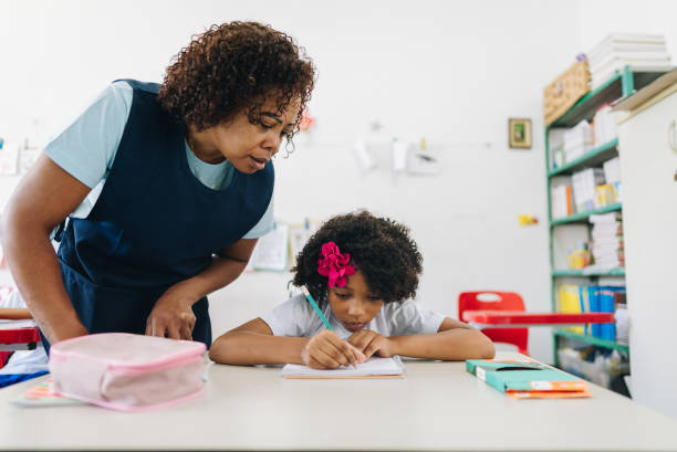 istock Teacher teaching her student on classroom at school 1899817436
