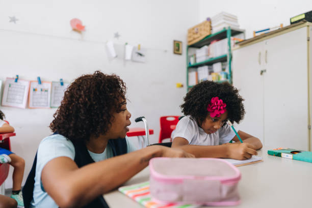 istock Teacher teaching her student on classroom at school 1899819134
