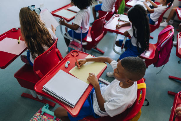 istock High angle view of boy student studying on classroom at school 1899822892