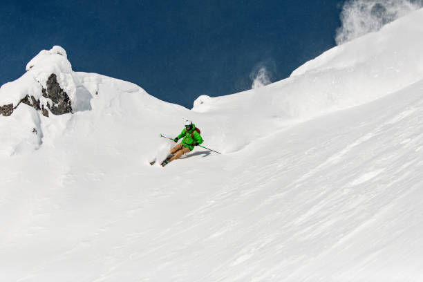 istock freeride skier energetically rides down on snow-covered mountain slope. 1899842745