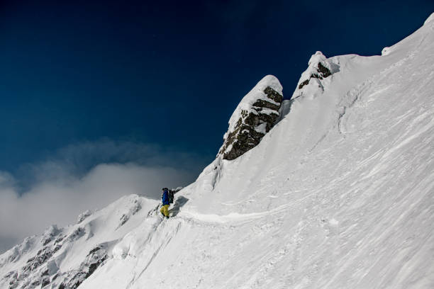 istock mountain slopes covered with white snow and male skier on it. 1899843690