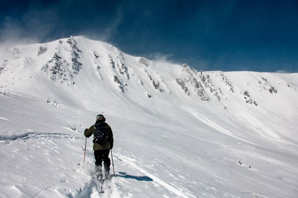 Skier skiing in the Swiss alps off-piste freestyle jumping performing tricks