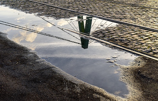 Spiegelung in einer Regenpfütze von einer Brückenpylone