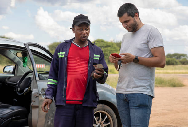istock two drivers exchanging insurance information after an accident pulled on the side of the highway 1899928184