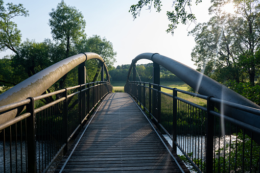View of a metal and wooden pedestrian bridge in green nature