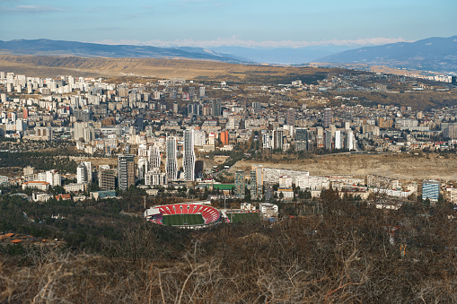 Tbilisi, Georgia 01.01. 2024: View from the mountain of the M Meskhi stadium and the Vake and Saburtalo districts, views of Caucasus ridge and Kazbegi Mountain, hiking along popular tourist routes.
