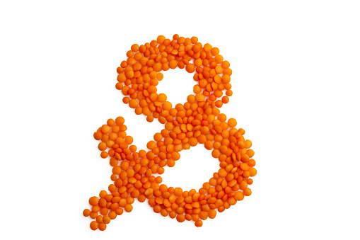 The symbol 'ampersand &' formed from red lentil grains against a clean white backdrop. A harmonious blend of organic elements and typography, it captures the essence of eco-friendly, vegetarian artistry. Perfect for a food blog and menu