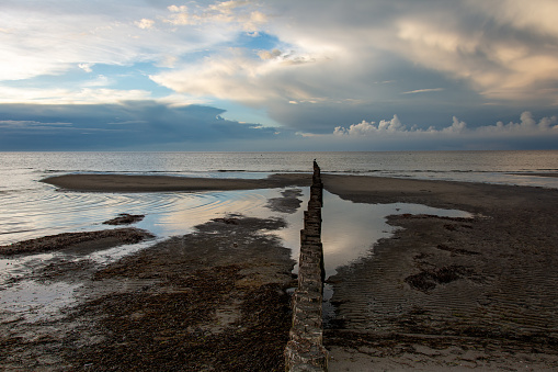 Breakwater on the Baltic Sea coast at low tide  with sky and clouds