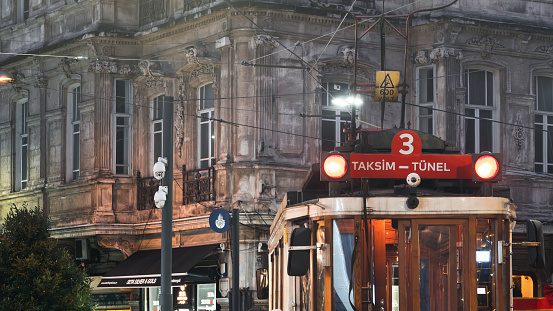 Istanbul, Taksim, Turkey Dec.8 2023 Historical  Red Tram at night with orange vehicle lights. Trams are the most historical and nostalgic vehicles on Istiklal Street in Taksim
