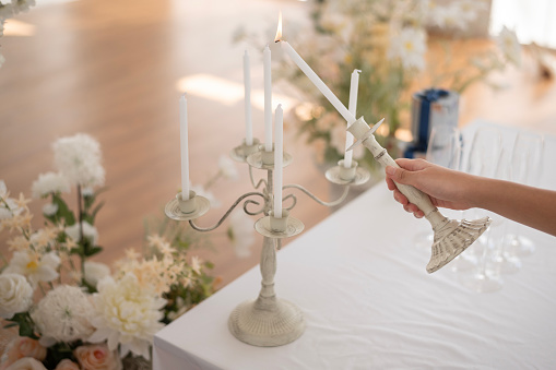 Close up of Bride and groom holding wedding candle during engagement ceremony