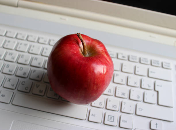 rozmyte przyciski białej klawiatury z soczystymi owocami czerwonego jabłka - cyrylica zdjęcia i obrazy z banku zdjęć