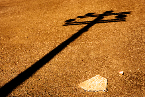 Detail of basefall on field with home plate and shadow of lights