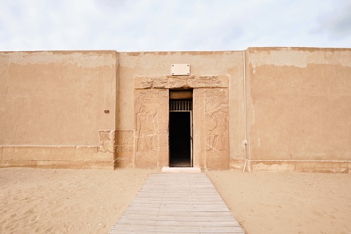 Saqqara, Egypt - January 2, 2024: Hieroglyphs and drawings on the entrance of a Mastaba