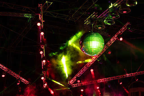 Large disco ball with stage lighting at an outdoor party