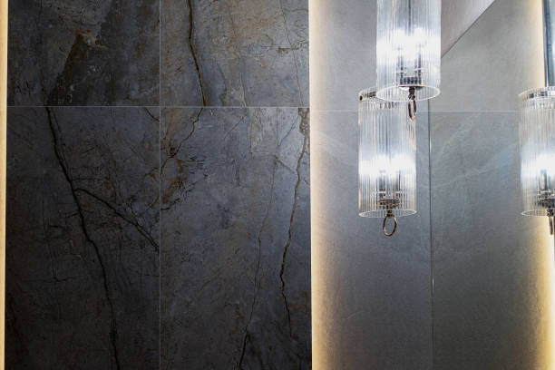 Three modern sconce lights mounted near mirrors in a bathroom