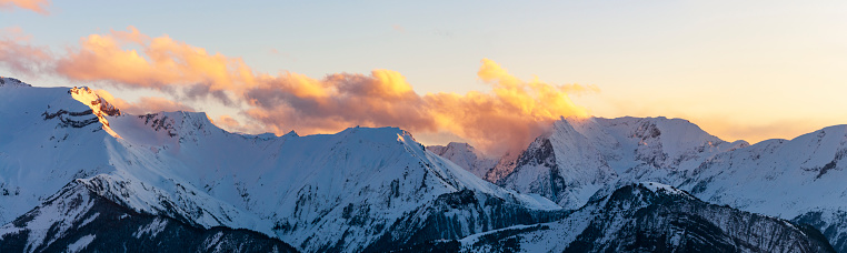 A panoramic of wintery and cloudy day at sunset in the Alps and mountains of France